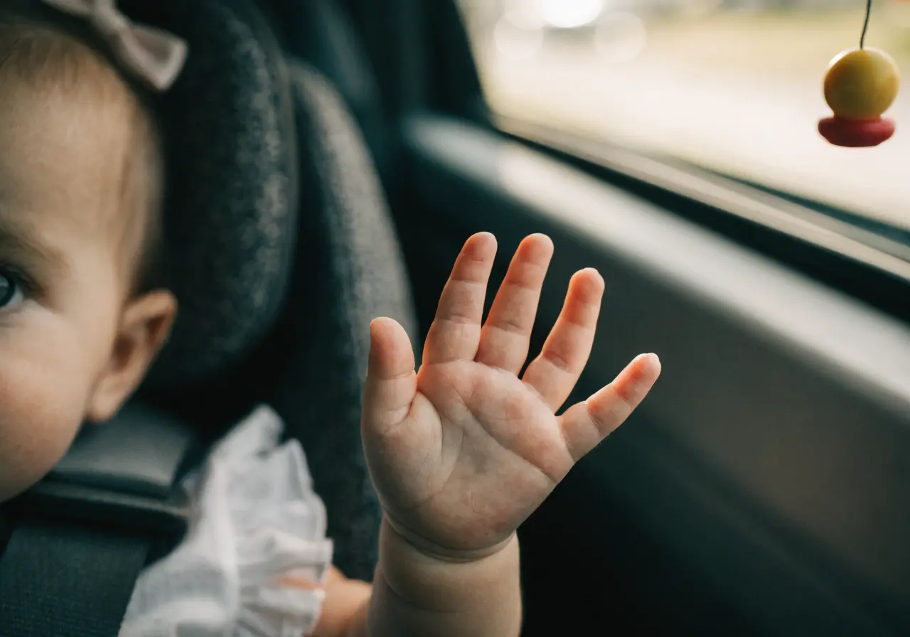 Toddler looking pale in a car seat during a road trip