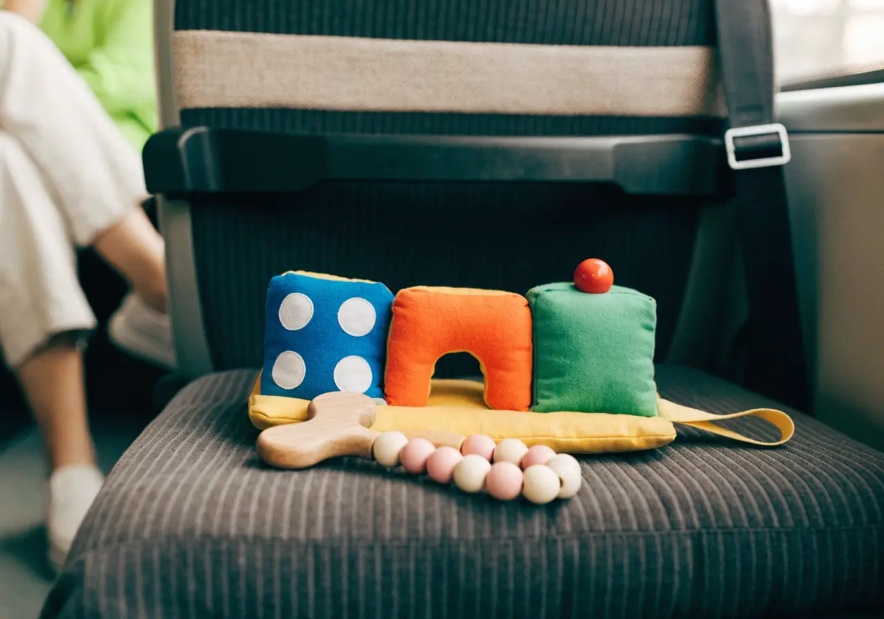 1 year old playing with travel toys in an airplane seat