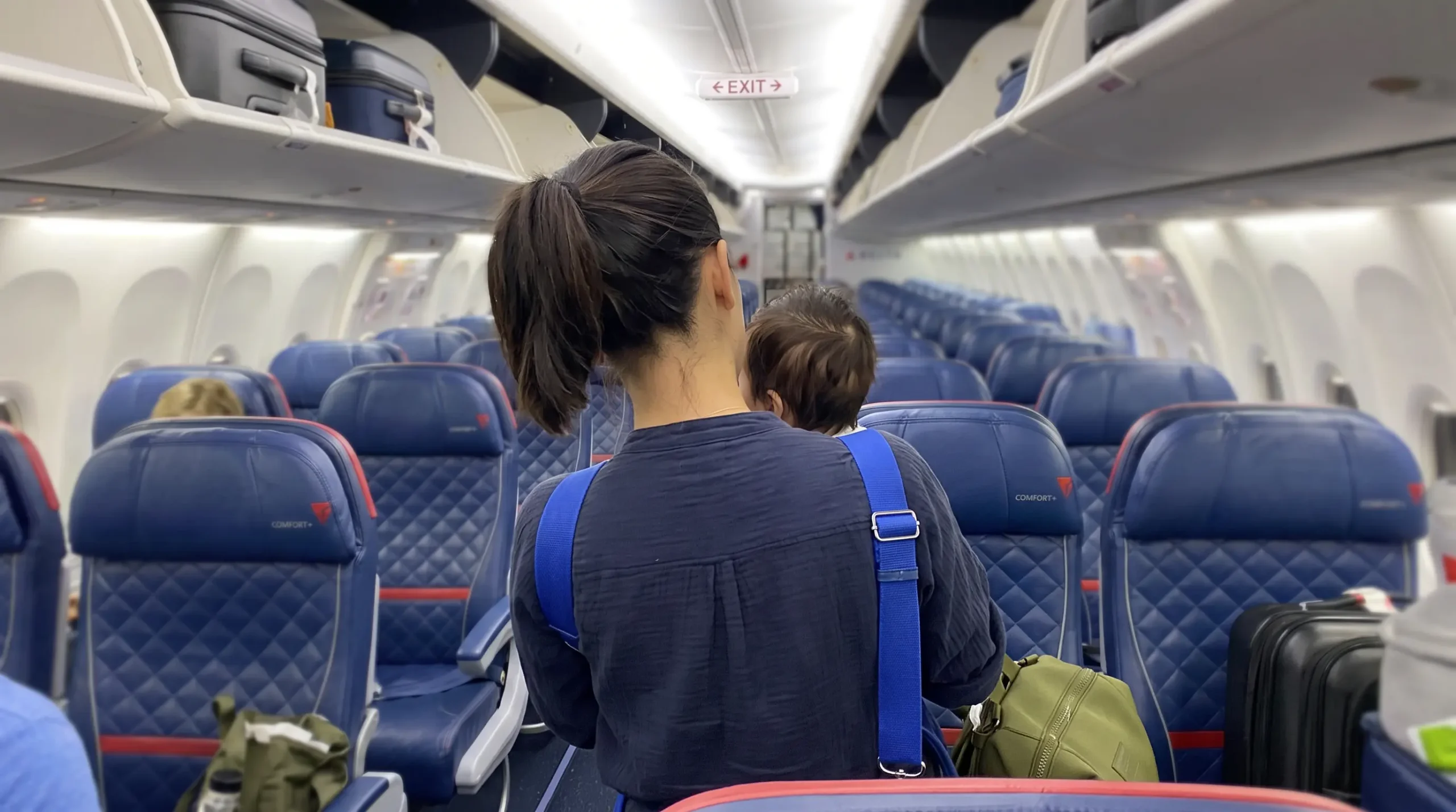 Parent boarding a Delta flight with a baby in a carrier