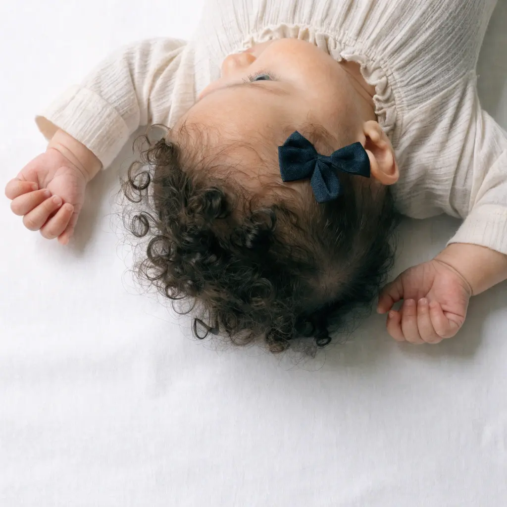 Newborn baby lying on a white sheet for a passport photo
