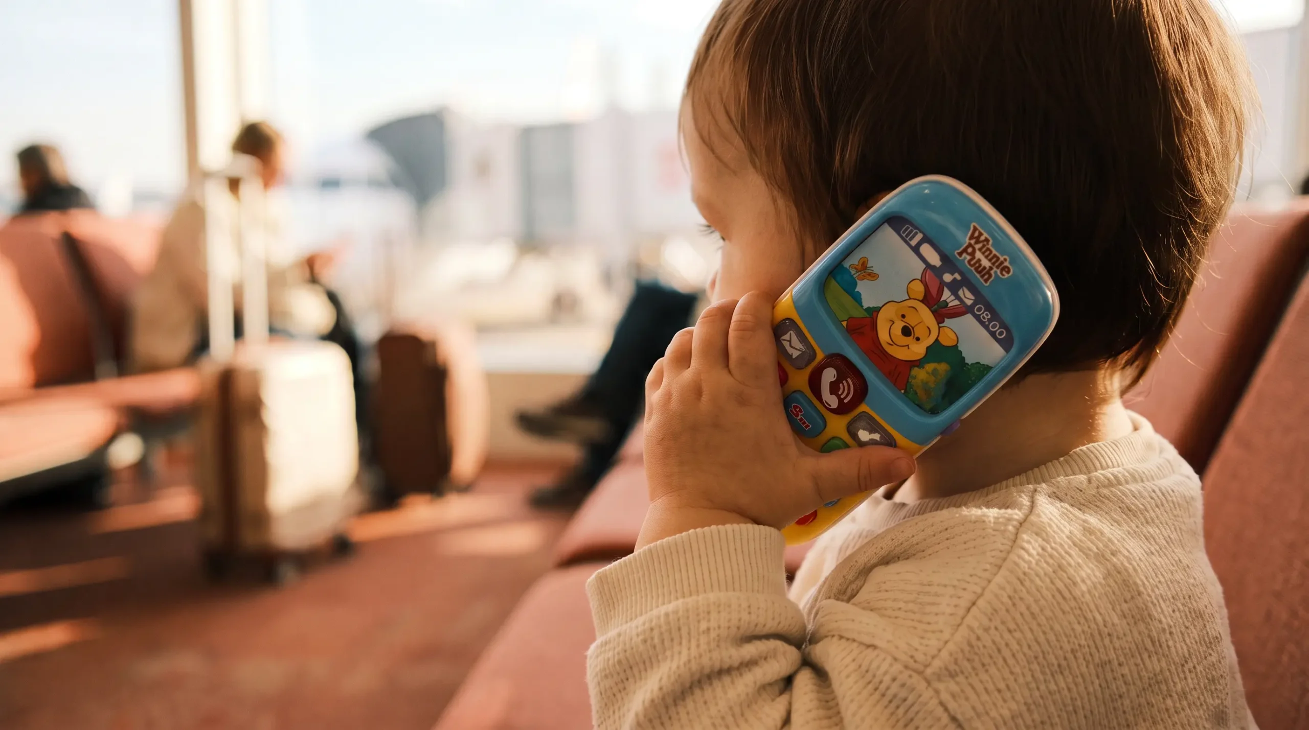 Baby holding a toy phone as a travel toy