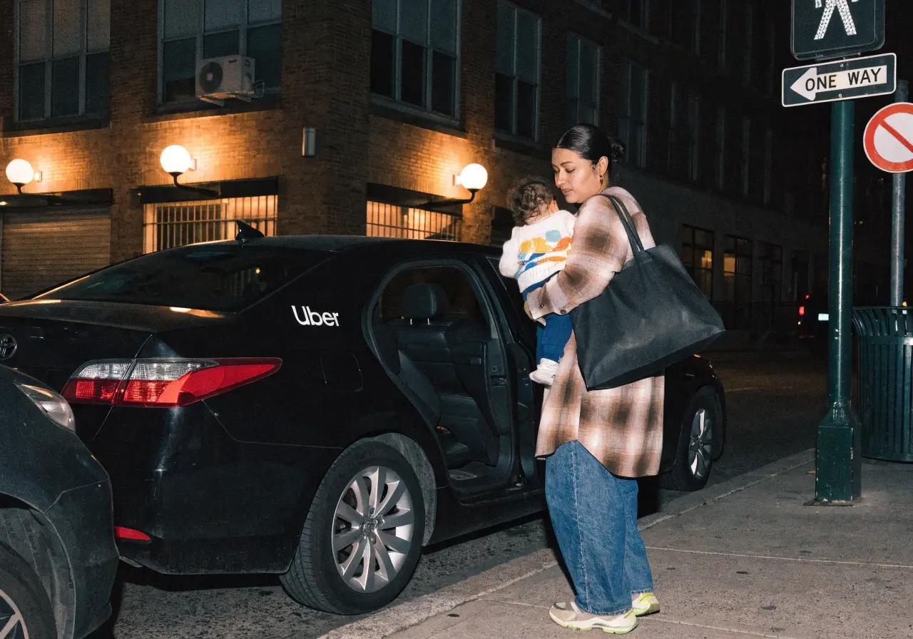 Parent buckling a baby into a car seat before a rideshare trip