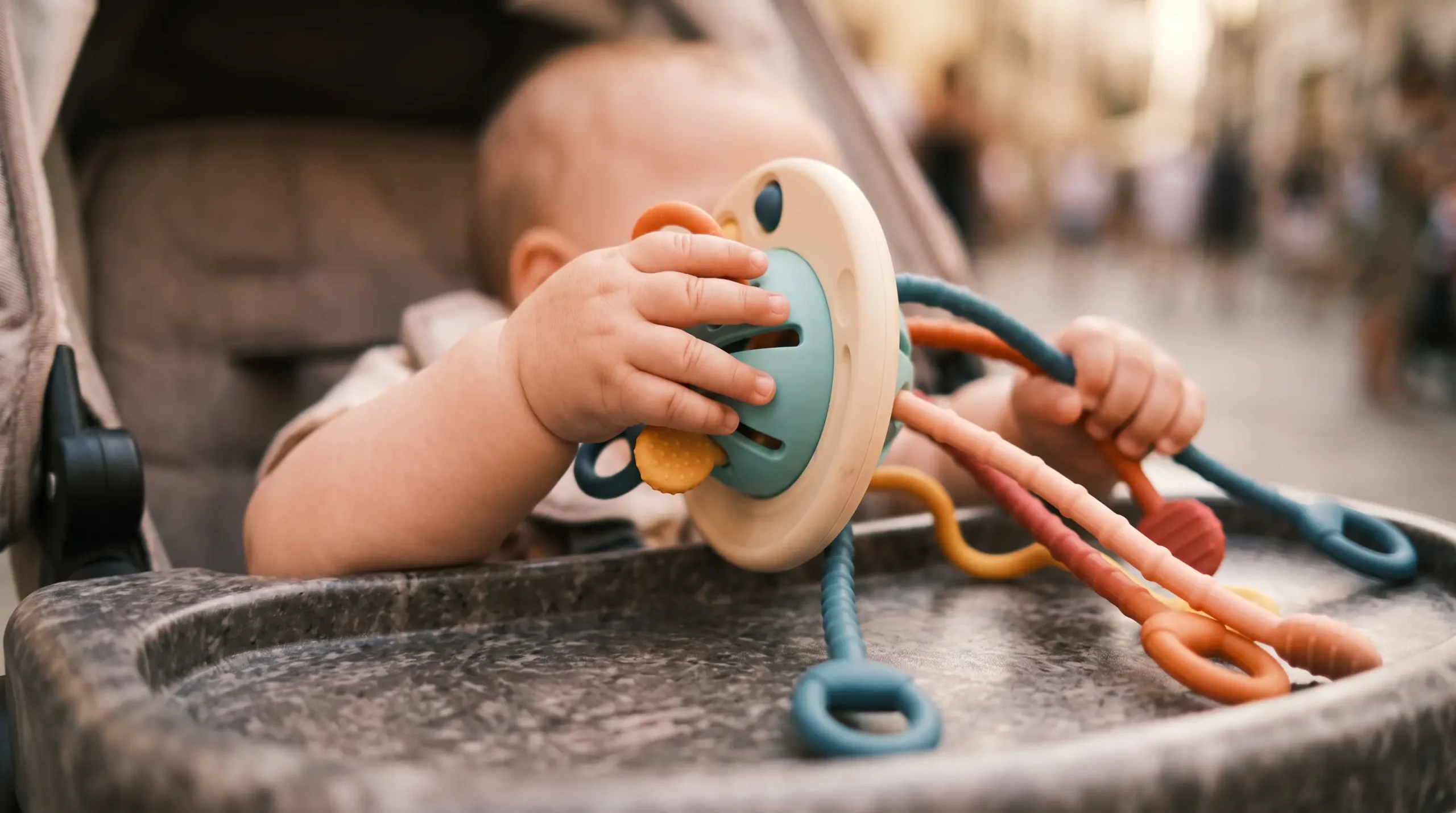 Round sensory toy with textured strings for a 1 year old